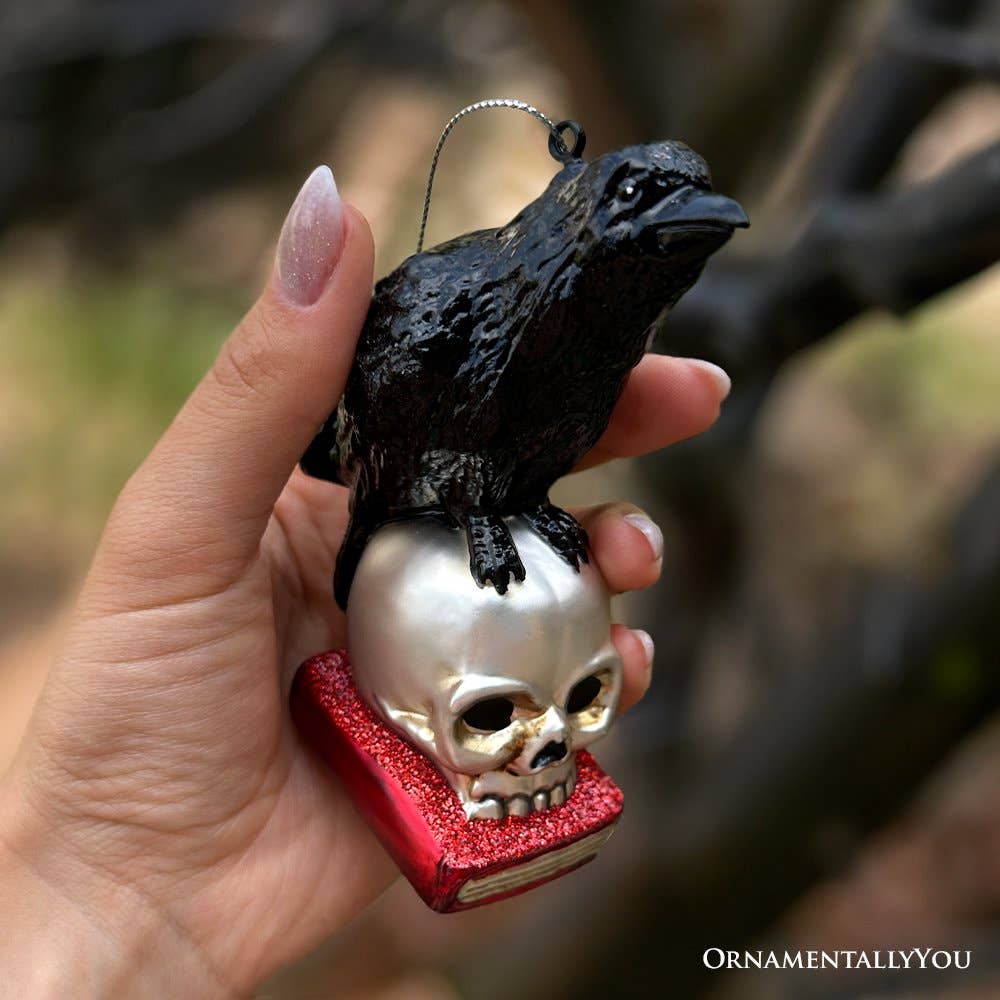 RAVEN ON SKULL AND BOOK GLASS HOLIDAY ORNAMENT
