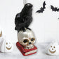 RAVEN ON SKULL AND BOOK GLASS HOLIDAY ORNAMENT
