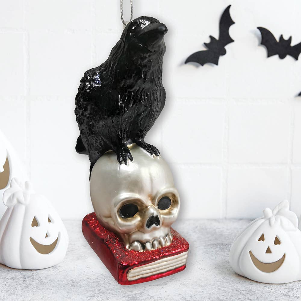 RAVEN ON SKULL AND BOOK GLASS HOLIDAY ORNAMENT
